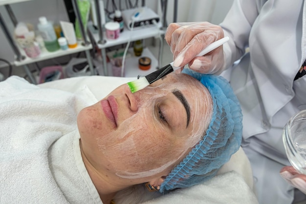 professionele schoonheidsspecialist voert ultrasone reiniging van de huid van het gezicht uit met behulp van een apparaat Cosmetische procedure in de salon van de schoonheidskliniek Het concept van machinecosmetologie