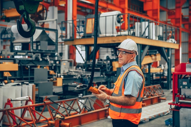 Professionele senior ingenieur mannelijke machine-operator voorman werknemer werk in de fabriek van de zware industrie