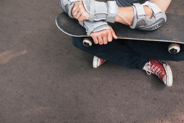 Professionele skater zit met skate, klaar voor de volgende wedstrijd. Extreme sportuitdaging en training, skateboarder moderne levensstijl en cultuur van jongerenachtergrond met vrije ruimte