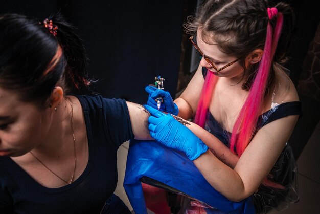 Professionele tatoeëerder maakt tatoeage in salon