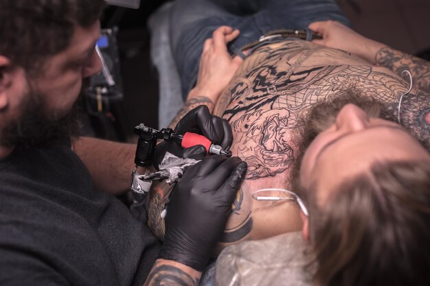 Professionele tattoo-artiest maakt tattoo-foto's in de salon