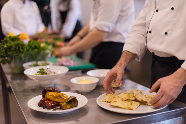 Professionele teamkoks en chef-koks bereiden maaltijden in de drukke hotel- of restaurantkeuken