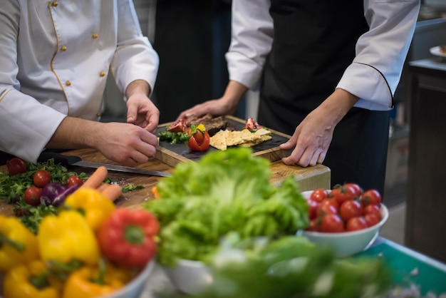 Professionele teamkoks en chef-koks bereiden maaltijden in de drukke hotel- of restaurantkeuken