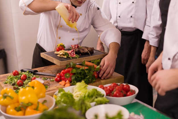 Professionele teamkoks en chef-koks bereiden maaltijden in de drukke hotel- of restaurantkeuken