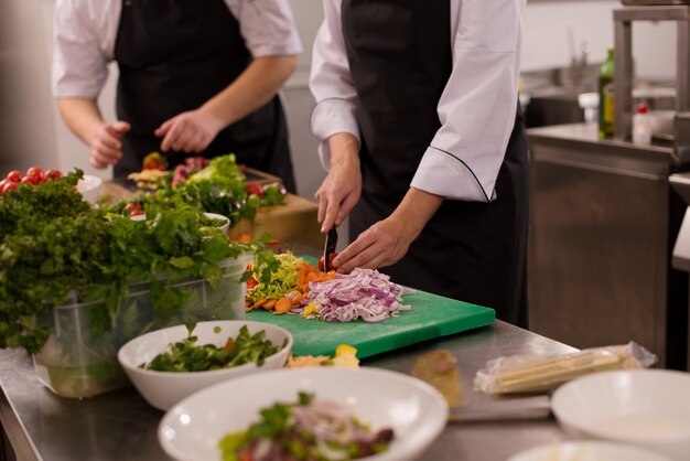 Professionele teamkoks en chef-koks bereiden maaltijden in de drukke hotel- of restaurantkeuken