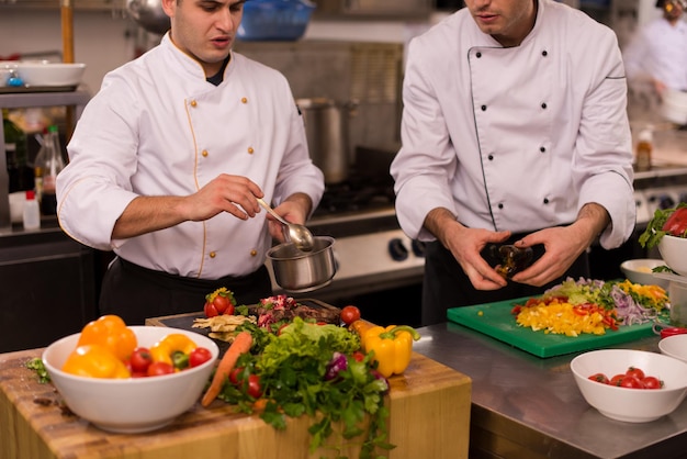 Professionele teamkoks en chef-koks bereiden maaltijden in de drukke hotel- of restaurantkeuken