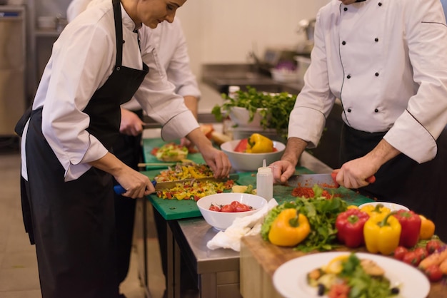 Foto professionele teamkoks en chef-koks bereiden maaltijden in de drukke hotel- of restaurantkeuken