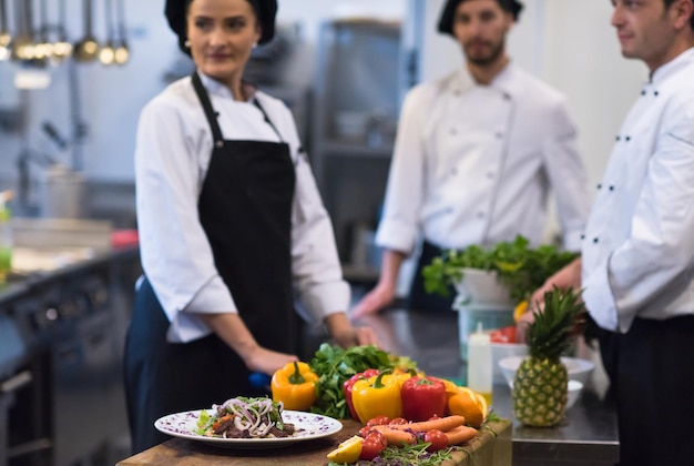 Professionele teamkoks en chef-koks die maaltijden bereiden in de drukke hotel- of restaurantkeuken