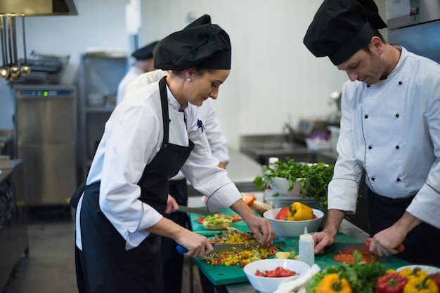 Professionele teamkoks en chef-koks die maaltijden bereiden in de drukke hotel- of restaurantkeuken