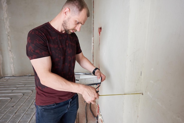 Professionele technicus die de muur in nieuw appartement meet