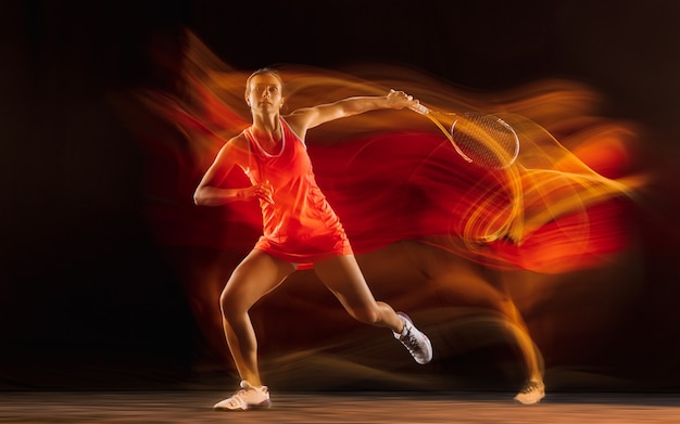 Professionele tennisspeelster geïsoleerd op zwarte studio achtergrond in gemengd licht