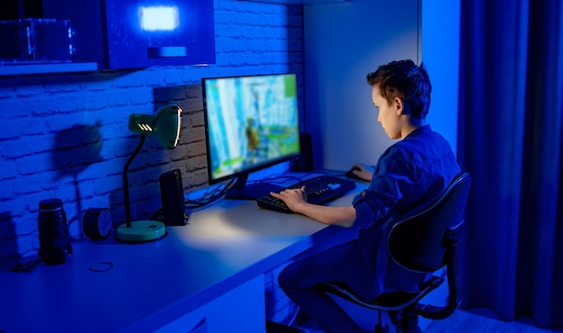 Professionele tiener gamer jongen. Jonge jongen speelt videogames. Verslaafd aan videogames thuis.