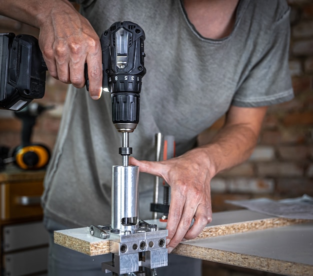 Professionele timmerman die met hout werkt en gereedschappen in huis bouwt.