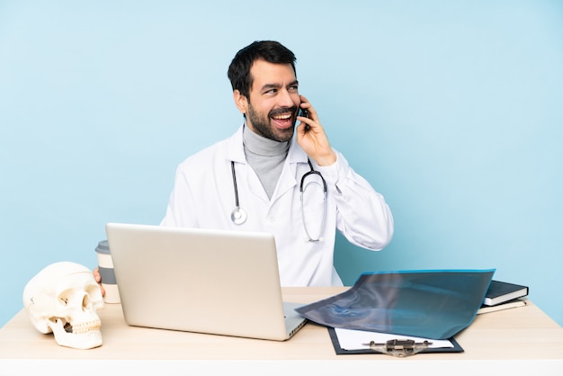 Professionele traumatoloog op de werkplek een gesprek houden met de mobiele telefoon