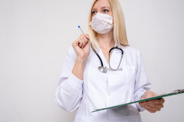 Professionele vrouw arts arts wit uniform met stethoscoop en recept bord, het lezen van een anamnese