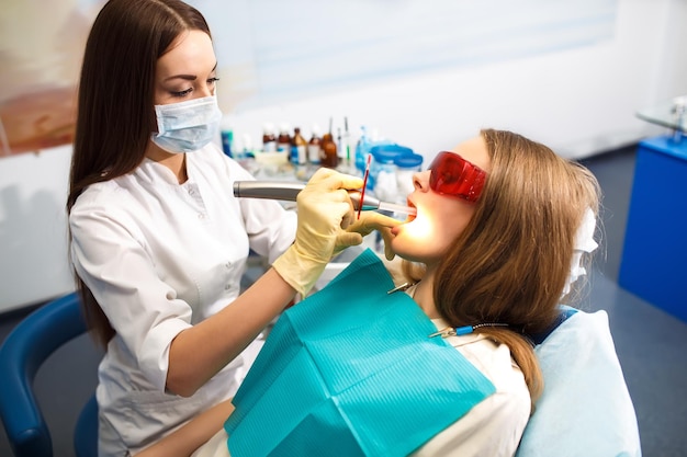 Professionele vrouw tandarts arts werkende vrouw tandheelkundige kliniek vrouw tandarts het verzorgen van tanden
