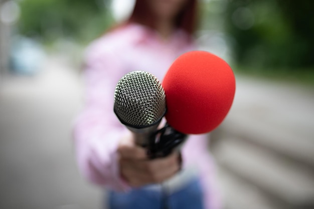 Foto professionele vrouwelijke journalist op een persconferentie die aantekeningen schrijft met een microfoon in de hand