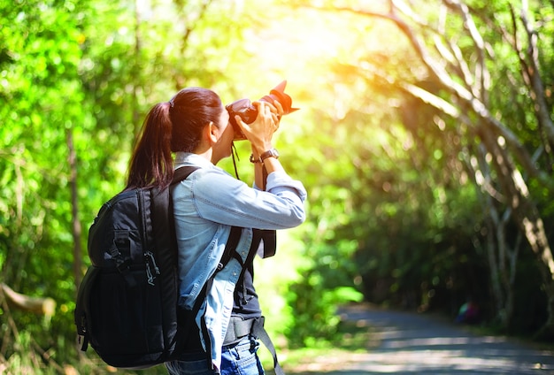 Professionele vrouwenfotograaf die openluchtportretten met eerste lens nemen