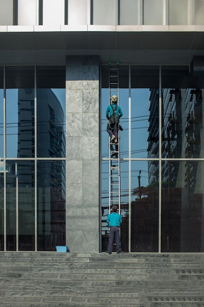 Professionele werkers met wasgereedschap op spiegel exterieur Bouwpanelen