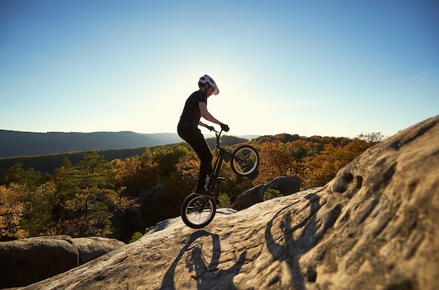 Professionele wielrenner balanceren op proeffiets bij zonsondergang