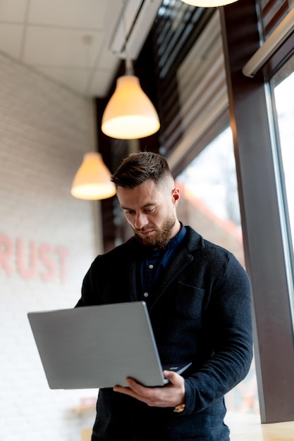 Professionele zakenman die met laptop werkt Freelance manager die in modern bureau werkt