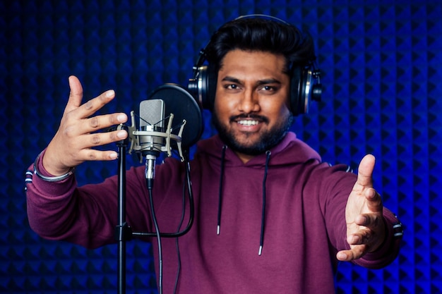 Professionele zingende Indiase mannen hoofdtelefoons klinken modern studio violet achtergrond opname lied.