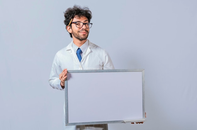 Professor in white coat holding small blank blackboard isolated Scientist in glasses in a white coat is holding a blank whiteboard Scientist showing blank whiteboard concept