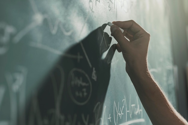Фото Профессор пишет математические формулы на доске рукой вблизи