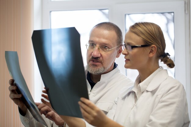 Professor and young doctor comparing x-rays