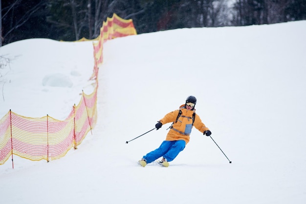 Proficient young skier concentrated on skiing down on steep ski slope