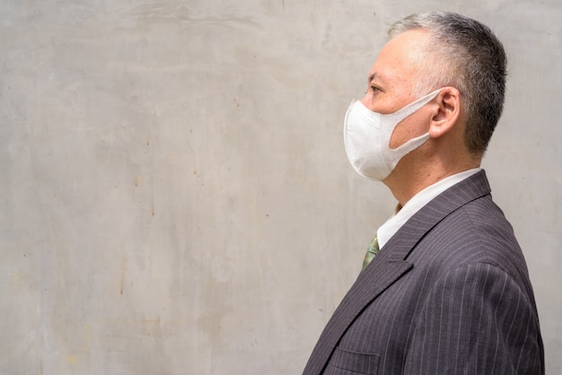 Profiel te bekijken van volwassen japanse zakenman met masker buitenshuis