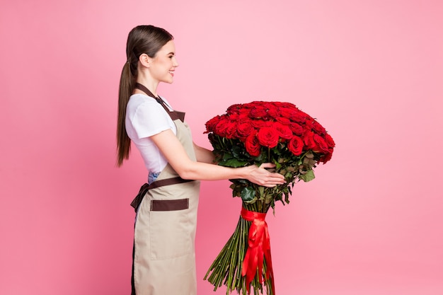 Profiel zijaanzicht portret van meisje met in handen grote rode rozen boeket