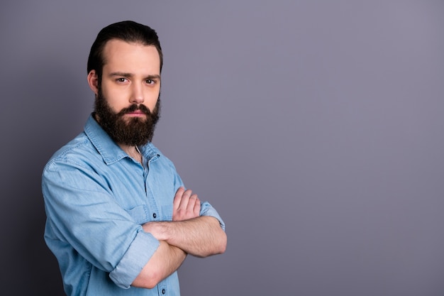 Profielfoto van macho kerel ernstig perfect uiterlijk netjes lang kapsel borstel jonge chef gekruiste armen niet glimlachend dragen casual denim outfit geïsoleerde grijze kleur muur