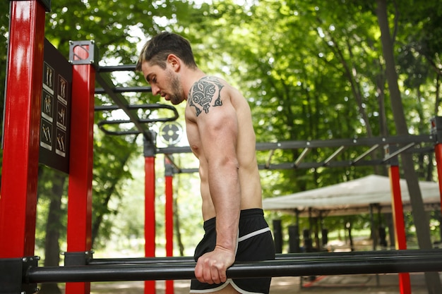 Profielfoto van sportman die triceps dips buitenshuis doet