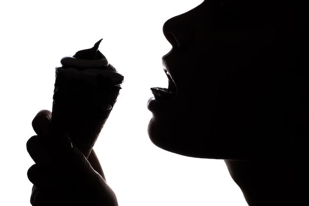 Profile close up photo of woman with open mouse holding ice cream