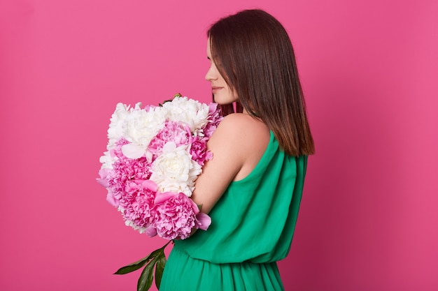 Profile of fragile beautiful young lady posing isolated over pink