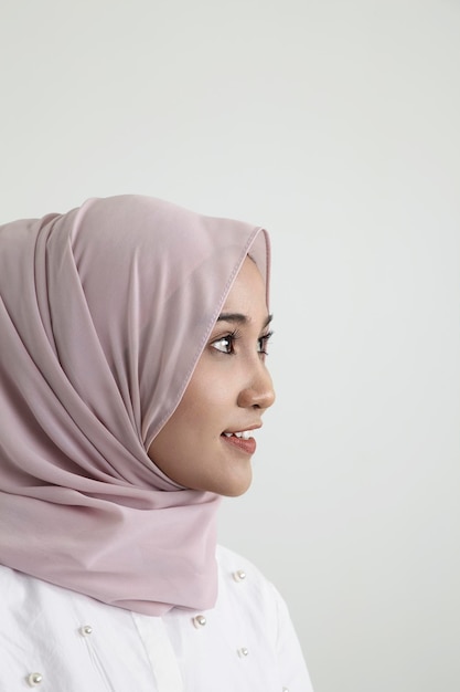 写真 白い背景のヒジャブを着た笑顔の若い女性のプロフィール