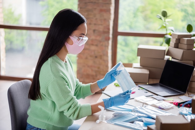 Profile photo of asian lady family business organize order facial flu medical mask sending prepare delivery check anti viral safety put respirators into zipper bag stay home office indoors