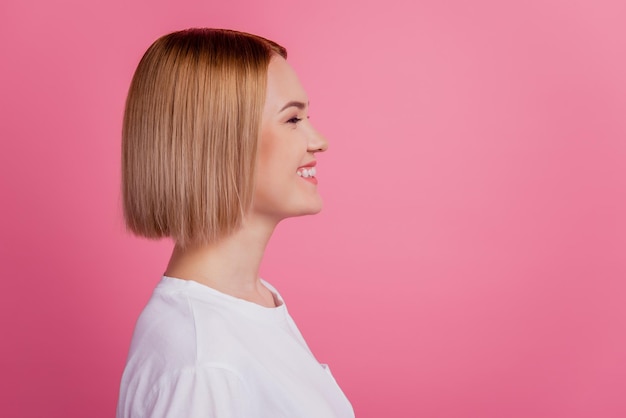 Profile photo of cheerful lady beaming toothy smile look empty space wear white t-shirt isolated on pink background