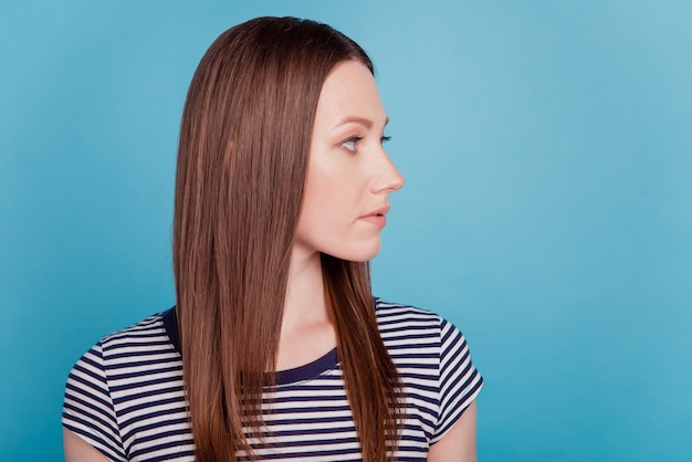 Profile portrait of calm confident pretty lady look empty space on blue background