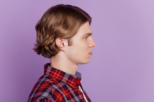 Profile portrait of calm focused guy look empty blank space on purple background