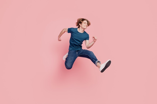 Profile portrait of handsome energetic athlete guy jump hurry shopping season concept on pink background