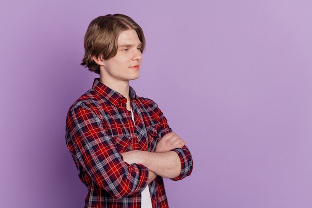 Profile portrait of nice cheerful cool guy crossed hands look empty space posing on purple background