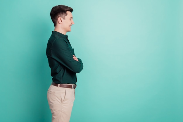 Profile portrait of successful cool man look empty space crossed hands on teal background