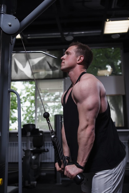 Photo profile shot of a male bodybuilder doing triceps exercise