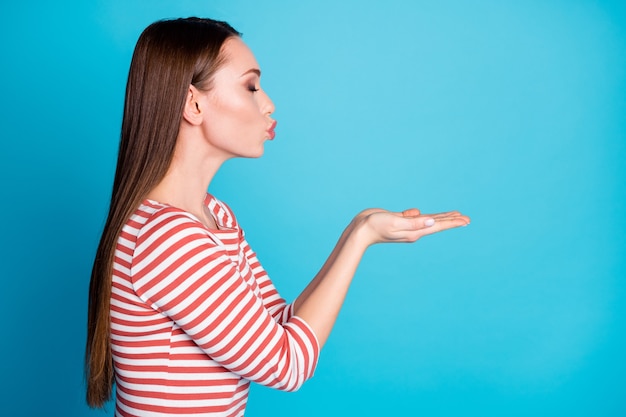 Profile side photo of nice charming girl lover hold hand send air kiss copyspace her boyfriend wear look good shirt isolated over blue color background