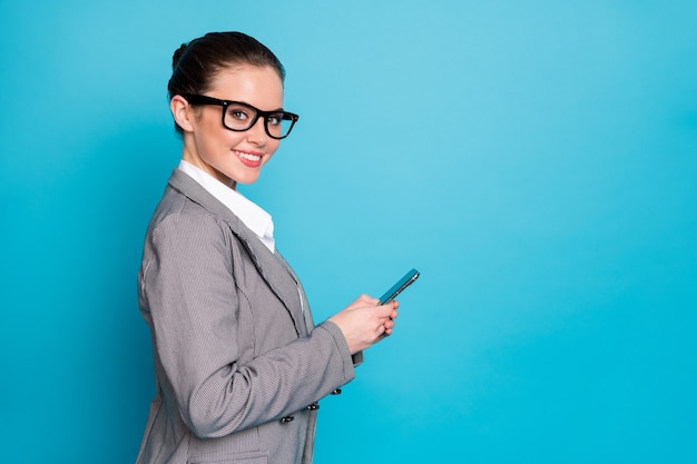 Profile side photo of positive girl broker use smartphone blogging wear blazer jacket isolated blue color background