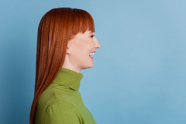 Photo profile side photo of positive woman look empty space isolated over blue background