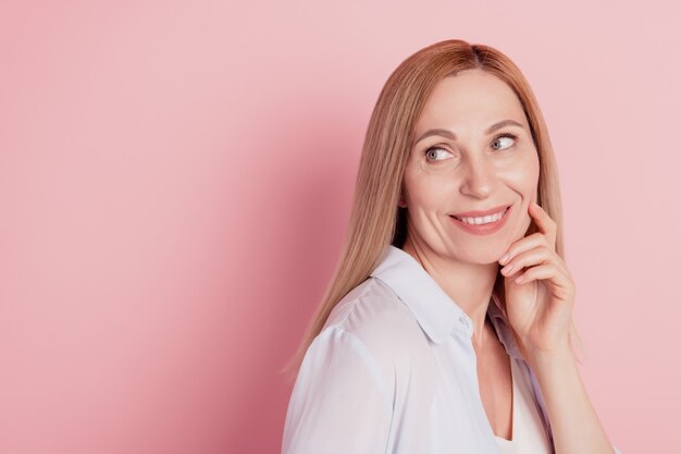 若い魅力的なきれいな女性の手タッチあごのプロフィールサイド写真は空のスペースを分離パステルカラーの背景に見えます