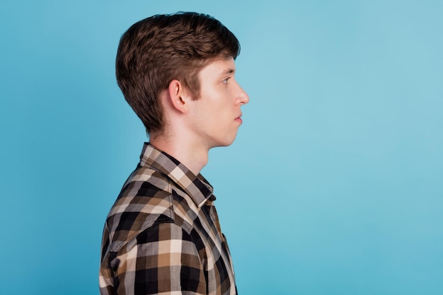 Profile side photo of young guy calm peaceful wear casual outfit look empty space isolated over blue color background